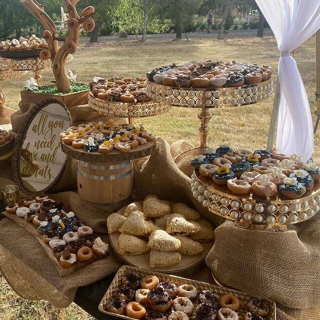 Rustic Dessert Table Setup With Jute Fabric, Wood Slices, Decorative Trays, & Cake Stands 