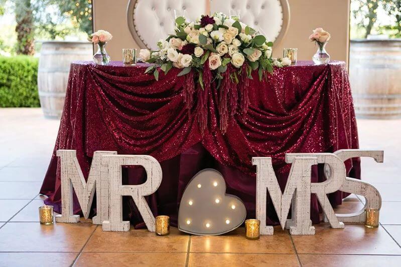 Sweetheart Table Décor With Tablecloths, Flowers, Vases, Candle Holders And Marquee Lights