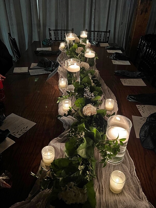 Graceful tablescape With Runner, Leaf Garland, Flowers, Cylinder Vases, Candles, & Votive Candle Hol