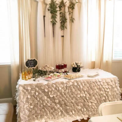 Blissful Brunch Table Setup Featuring Tablecloth, Garlands, Tulle Fabric, & Serving Trays