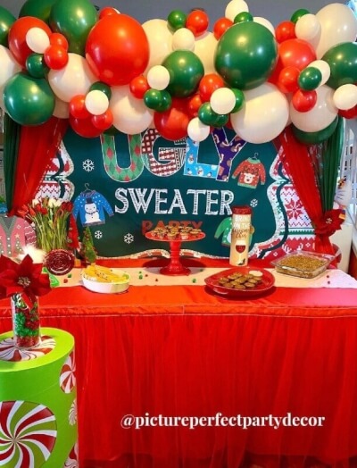 Peppy Ugly Sweater Party Decor With Curtains, Balloons, Table Linens, Cake Stand, & Flowers