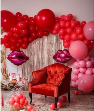 Intimate Valentine’s Day Décor Using Fringe Curtains, Red & Pink Balloons, and Red Confetti 