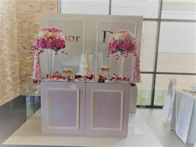 Dior Themed Party Décor With Letter Stickers, Pedestal Risers, Trumpet Vase, & Flowers