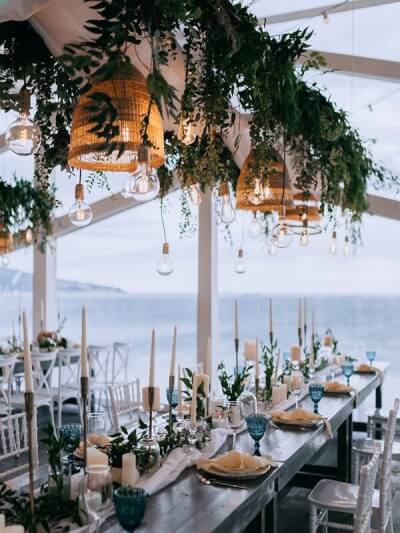 Outdoor Tablescape With Runner, Candles, Napkins, Chargers, Garlands, String Lights, & Cutlery 