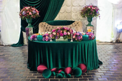Enchanting Green Head Table with Backdrop, Tablecloth, Balloons, Centerpieces, and Silk Bouquets