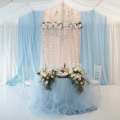 Lovely Wedding Table Setup with Drapes, Tablecloths, Garlands and Bouquets