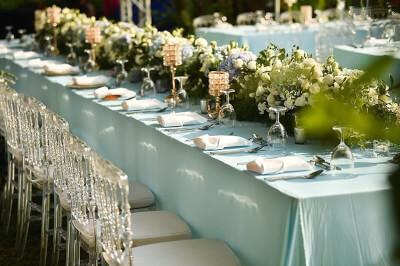Exquisite Wedding Setup with Tablecloth, Table Napkins, Wine Glasses and Flower Arrangement