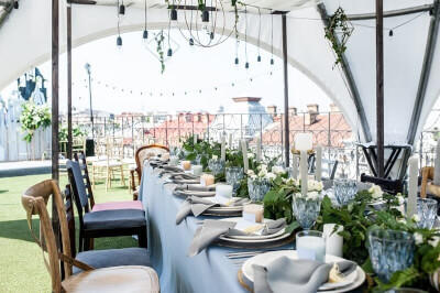 Pleasant Outdoor Wedding Lunch Table Setup with Tablecloth, Table Napkins, Candles, Wine Glasses and
