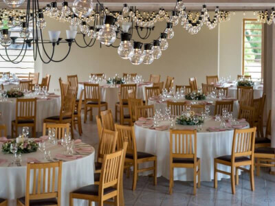 Classic Wedding Setting using Tablecloths, String Lights, Wine Glasses, Table Napkins and Flower Bou