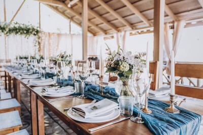 Rustic Wedding Setup using Table Runner, Flowers, Charger Plates, Wine Glasses, Candles and Table Na