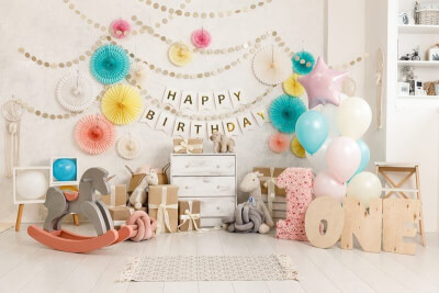 Charming Child’s Birthday Setup with Garlands, Banners, Balloons and Paper Fans