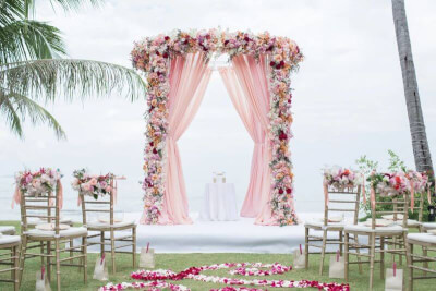 Gorgeous Outdoor Wedding Setting using Wedding Arch, Drapes, Flowers and Floor Scatters