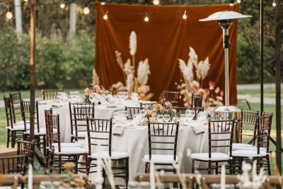 Elegant Outdoor Wedding Setup with Tablecloth, Table Napkins, String Lights, Flowers and Grass