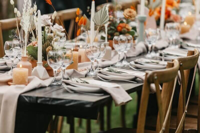 Lively Wedding Table Setup using Table Runner, Table Napkins, Candles, Flowers, and Grass