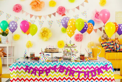 Vibrant Birthday Party Setup with Balloons, Tablecloth, Banners, Flower Balls & Dessert Holders