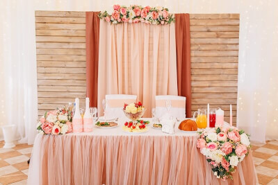 Gorgeous Indoor Wedding Setup Using Drapes, Table Skirt, Flowers & Chair Sashes