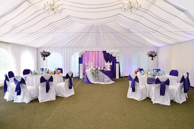 Modest Indoor Wedding Setup Using Curtains, Tablecloths, Chair Covers, Chair Sashes & Flowers