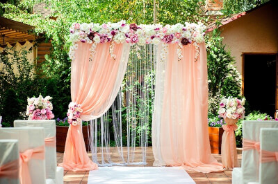 Dreamy Outdoor Wedding Scene Using Drapes, Flowers, Chair Covers, Chair Sashes & Aisle Runner
