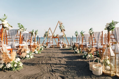 Exotic Beach Wedding Décor With Triangle Arch, Sashes, Pampas, Candles, Holders, Flowers & Greenery