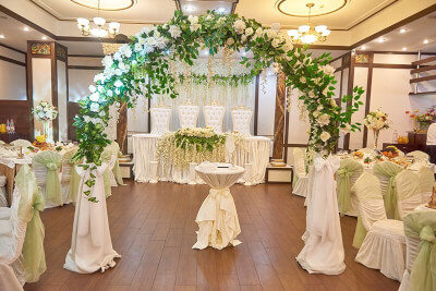 Green & White Indoor Wedding Decor With Wisteria Vines, Flower Garlands, Tablecloth, & Sashes