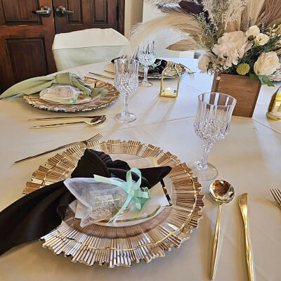Enticing Partyscape With Tablecloth, Charger, Lanterns, Cutlery, Flute, Planter, Feathers, & Floral