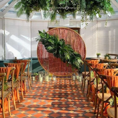 Rustic Indoor Wedding Venue Using Wedding Arch, Leaves, Chair Sashes & Beaded Curtains