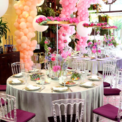 Vibrant Party Décor Using Balloons, Tablecloths, Chargers, Napkins, Flowers, & Chair Pads