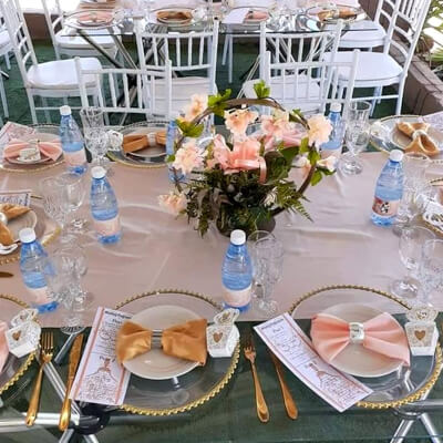 Stunning Table Setup With Tablecloth, Flowers, Chargers, Plates, Napkins, Cutlery, & Chair Pads