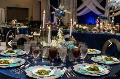 Lush Wedding Table Arrangement Using Tablecloth, Cloth Napkins, Candles, Flowers & Charger Plates