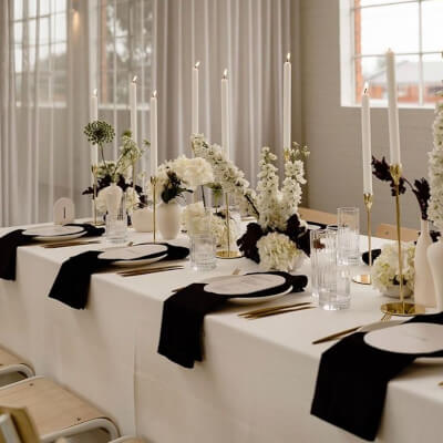 Mesmerizing Table Setup With Tablecloth, Flowers, Vases, Candles, Candle Stands, Napkins, & Cutlery