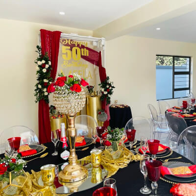 Vibrant 50th Birthday Party Décor Using Backdrop Stand, Curtains, Tablecloths, Chargers, & Flowers