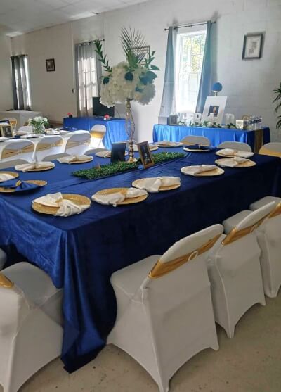 Timeless Sophistication with Navy Linens, Floral Centerpieces, and White Chair Covers with Sashes