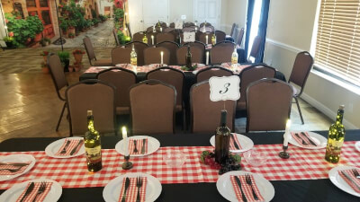 Charming Bistro-Style Décor with Red Gingham Runners, Wine Bottle Centerpieces, and Warm Lighting