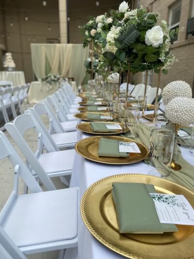 Chic Garden-Inspired Dining with White Folding Chairs, Sage Green Napkins, and Tall Floral Centerpie