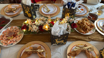 Festive Gold Holiday Table with Floral Centerpiece, Golden Tableware, and Gift Bags