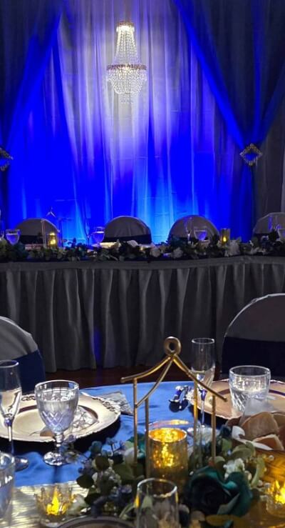 Chic Black-and-Blue Glow Reception, Crystal Chandelier, and Candlelit Centerpieces
