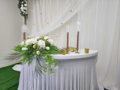 Minimalist Sweetheart Table with Flowing White Linen, Tall Candles, and Hanging Terrariums