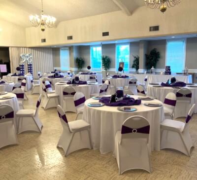 Contemporary Purple & White Décor with Round Tables and Spandex Chair Covers with Sashes