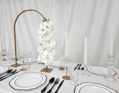 Minimalist Charm with White Tablescape, Black Accents, and a Golden Arch with Orchids