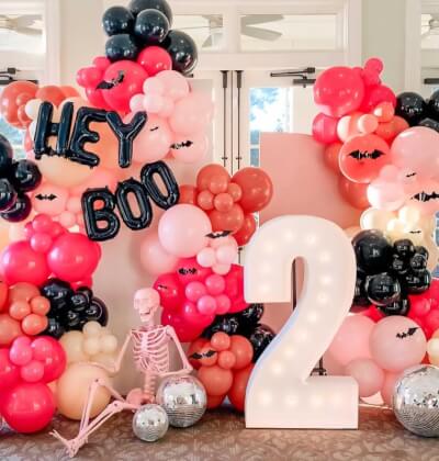 Playful Halloween Kids’ Party with Balloon Backdrop, Disco Balls, Light-Up Number and Skeleton Décor