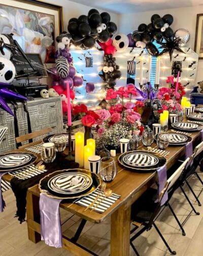 Spooky Chic Tablescape with Striped Dinnerware, Lavender Napkins, Vibrant Roses and Balloon Arches