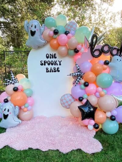 Whimsical Outdoor Pastel Halloween Display with Balloon Clusters, Star Accents, and Arched Backdrop