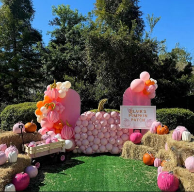 Pastel Pumpkin Patch Featuring Balloon Backdrop, Hay Bales, and Decorative Painted Pumpkins