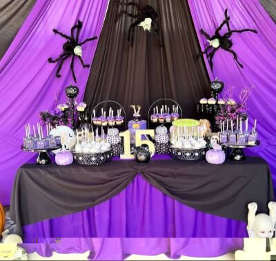 Gothic Spooky Sweet 15 Dessert Table with Purple Drapes, Black Linens, and Themed Treats