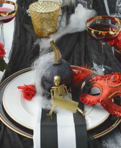 Halloween Masquerade Tablescape with Glitter Pumpkins, Gold-Rimmed Glassware and Cobweb Accents