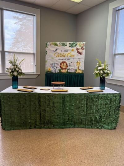 Jungle Safari-Themed Baby Shower Featuring Leafy Table Skirt, Animal Backdrop, and Elegant Florals