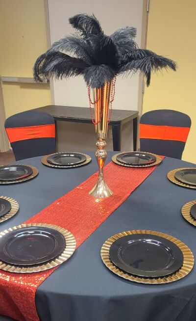 Bold Art Deco-Inspired Table with Black Covers, Red Accents, and Striking Feather Display
