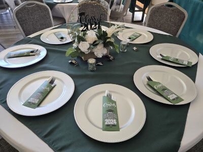 Toast to Success with Green Overlay, White Plates, Black Cutlery, and a Graduation Centerpiece