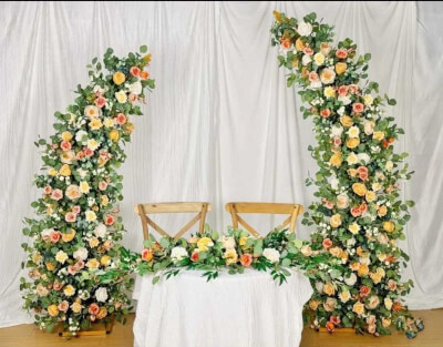 Romantic Garden Style with Blooming Floral Arches, White Linens, Backdrop, and Rustic Chairs