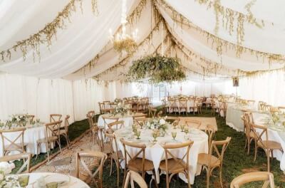 Rustic Tent Reception Styled with Draped Ceilings, White Linens, and Cascading Greenery